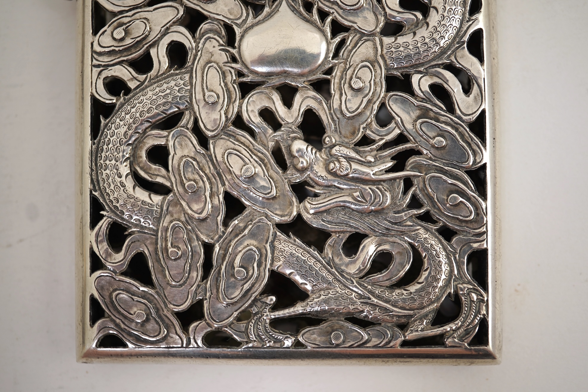 A late 19th century Chinese Export pierced silver card case, maker KMS(Kwong Man Shing), decorated with dragons amid clouds, 10.4cm, together with a Chinese Export pierced silver octagonal box and cover, by Luen Wo?, cir